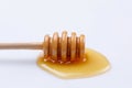 Wooden spoon stick with a drop of fragrant honey on a white background. Close-up Royalty Free Stock Photo