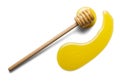 Wooden spoon stirrer and spread puddle of honey, isolated on white Royalty Free Stock Photo