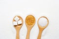 Wooden spoon with sugar on white granulated background Royalty Free Stock Photo