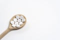 Wooden spoon with tablets on white background Royalty Free Stock Photo
