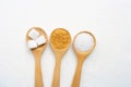 Wooden spoon with various types of sugar on white granulated sugar background Royalty Free Stock Photo