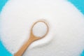 Wooden spoon with white granulated sugar on blue background Royalty Free Stock Photo