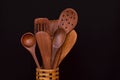 Wooden spoons in basket on table on black background Royalty Free Stock Photo