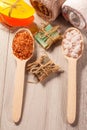 Wooden spoons with brown and white sea salt and handmade soap for bathroom procedures with towels on the background Royalty Free Stock Photo