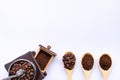 Wooden spoons filled with coffee bean and crushed ground coffee