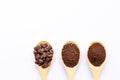 Wooden spoons filled with coffee bean and crushed ground coffee