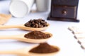 Wooden spoons filled with coffee bean and crushed ground coffee