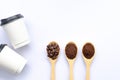 Wooden spoons filled with coffee bean and crushed ground coffee