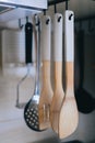 some wooden spoons hanging on hooks in the kitchen counter Royalty Free Stock Photo