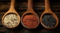 Wooden spoons hold quinoa varieties on rustic wood Royalty Free Stock Photo