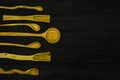 Wooden spoons lie on a black shabby wooden background