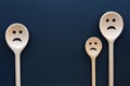 Wooden spoons look like sad family. Sorrowful faces.