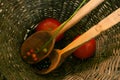 Wooden spoons in osier basket with tomatoes and black and red  berries Royalty Free Stock Photo