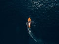 A wooden sports boat with people on board rides on the sea. Luxury wooden motor boat - top view from drone.