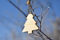 Wooden spruce on branch of tree