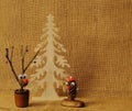 Wooden spruce, deer made of cones and twigs decorated with bells in ceramic glass and fabulous persona made of cones on homespun