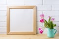 Wooden square frame mockup with pink tulip in mint pitcher vase Royalty Free Stock Photo