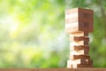 Wooden stack tower from wood blocks toy on greenery blurred background Royalty Free Stock Photo