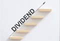 Wooden stair made by wooden cube block with text DIVIDEND Royalty Free Stock Photo