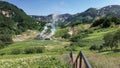 A wooden staircase descends into the Valley of Geysers.