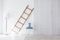 Wooden staircase floor lamp and chair in the interior of the white room