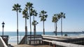 Wooden stairs, beach access in California USA. Coastal stairway, pacific ocean waves and palm trees.