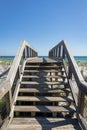 Wooden stairs of a boardwalk over the white sand dunes with grasses against ocean view at Destin, FL Royalty Free Stock Photo