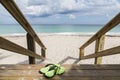 Wooden stairs on deserted beach duneswith green shoes Royalty Free Stock Photo