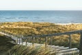 Wooden stairs through dunes and grass on Sylt island toward sea