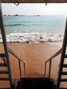 Wooden stairs leading down to the sea water on the beach. Royalty Free Stock Photo