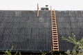 Wooden stairs on the roof. Chimney repair. Metal shell and damaged bricks Royalty Free Stock Photo