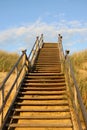 Wooden stairs surrounded by sand dunes and grass Royalty Free Stock Photo