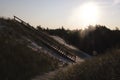 Wooden stairs to the beach covered with sand in surreal morning light. Low key abstract landscape. Lubiatowo sand dunes, foot path Royalty Free Stock Photo