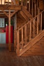 Room with wooden stairway leading to second floor of modern flat. Modern staircase with wooden steps in flat. Royalty Free Stock Photo