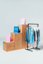 wooden stands with shopping bags and stand with clothes on white, summer