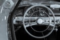 Wooden steering wheel and leather dashboard of a vintage car