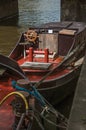 Wooden steering wheel on poop deck of boat moored on the canal side in Amsterdam. Royalty Free Stock Photo