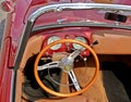 Wooden steering wheel of a Sixties italian convertible Fiat, during a vintage car gathering.