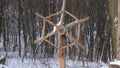 Wooden steering wheel on white snow forest background. Budhism symbol sansara wheel 4K.