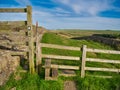 A wooden step stile with signs crosses a fence between two fields on the Hadrian`s Wall Path in Northumberland, England, UK Royalty Free Stock Photo