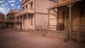 Wooden steps and entrance to house on a old American western street with hotel and saloon in the background. 3D rendering