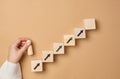 Wooden steps and a figurine of a little man in a woman's hand. Startup, starting a new successful business Royalty Free Stock Photo