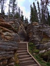 Wooden steps leading through narrow gap between colorful eroded rocks with visible layers in forest near Athabasca Falls, Canada. Royalty Free Stock Photo