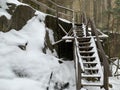 Wooden steps near the cliff. Staircase made of wood in the snow. Wooden structure for climbing the mountain Royalty Free Stock Photo