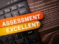 Wooden stick and keyboard with the word ASSESSMENT EXCELLENT Royalty Free Stock Photo
