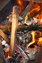 Wooden sticks and ashes from burnt paper engulfed in fire, burning coals in a charcoal grill Royalty Free Stock Photo