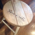 Wooden stool with invitation to sit