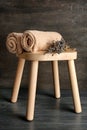 Wooden stool with soft towels and dry lavender on dark background