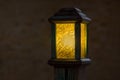 Wooden street lamp with yellow glass diffuser.