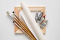 Wooden stretcher bar, paintbrushes, roll of artist canvas and paint tubes. Royalty Free Stock Photo